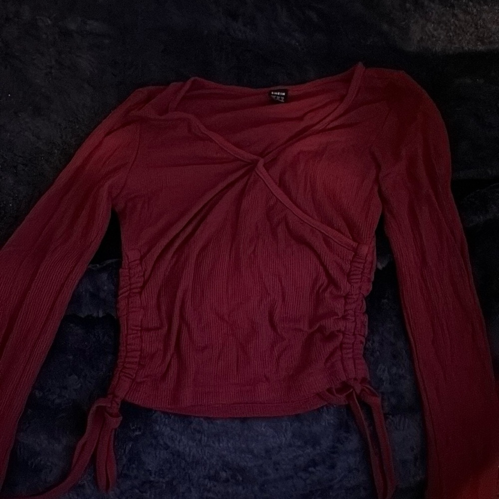 Maroon long sleeve with cross in front.